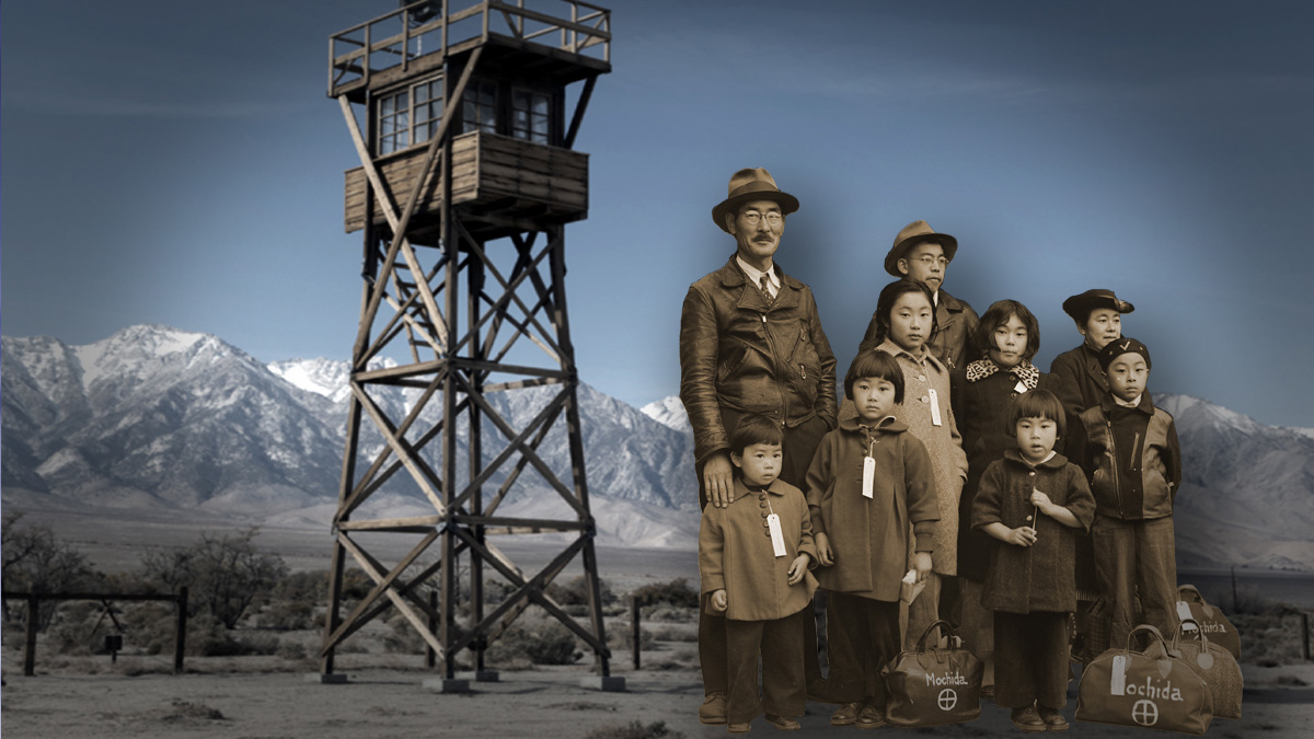 A Japanese-American family of six from the 1940s. Each has a tag on their coat. They are standing in front an internment camp observation tower.