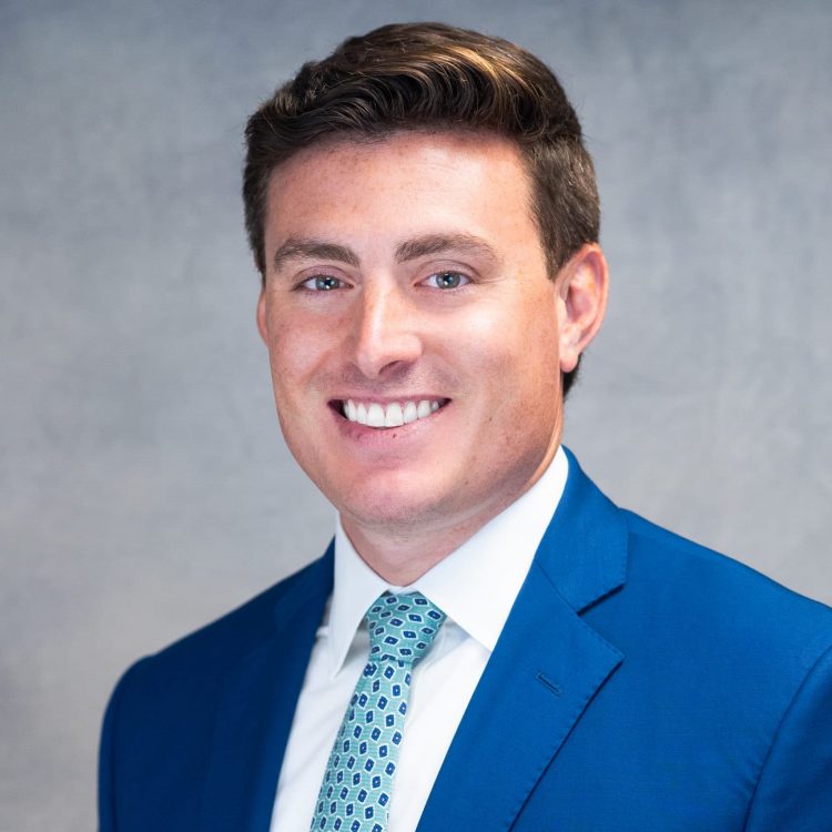 Man in blue suit with a white shirt and ight blue tie